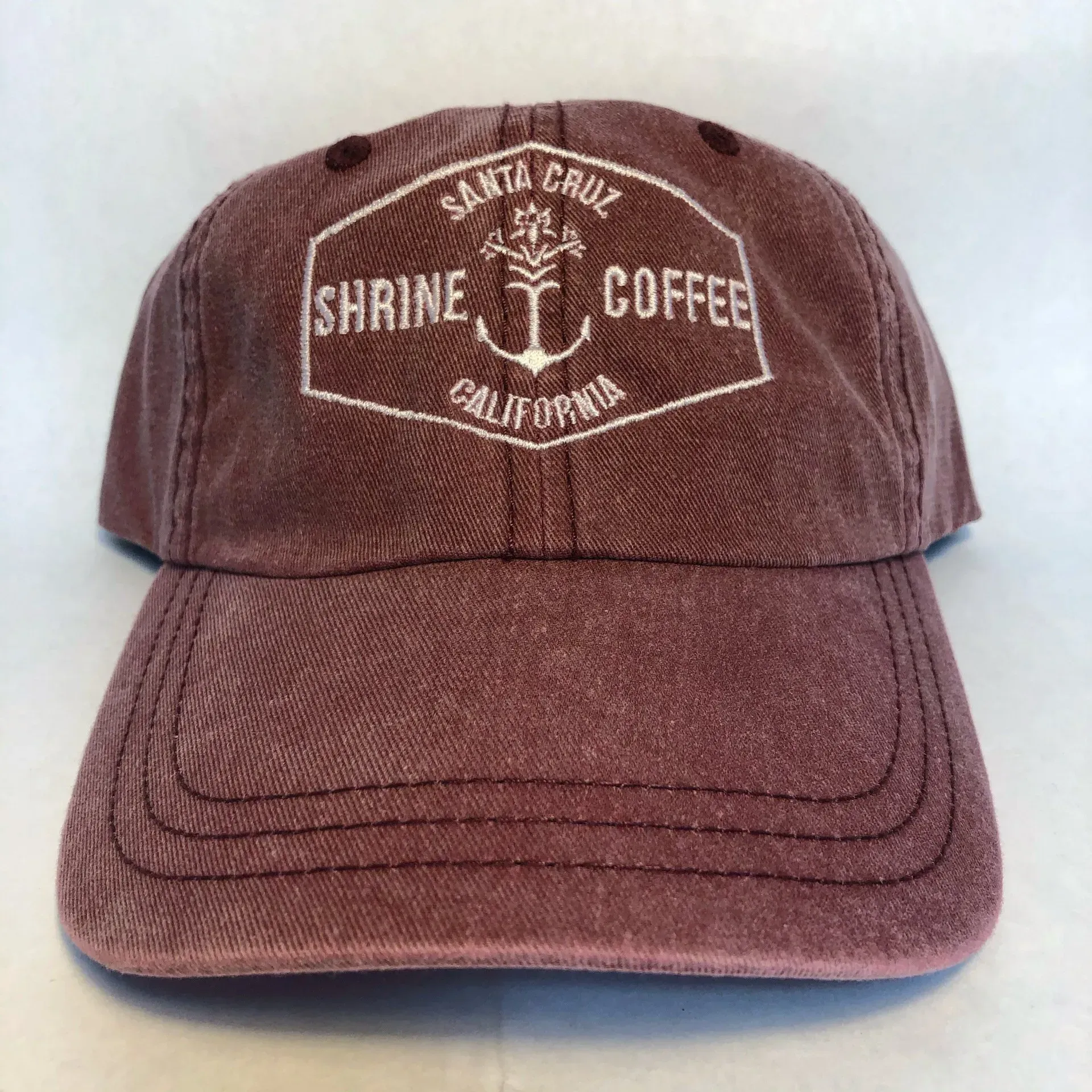A Maroon Baseball Cap that says Santa Cruz Shrine Coffee California, Soquel, CA, Sport About Graphics